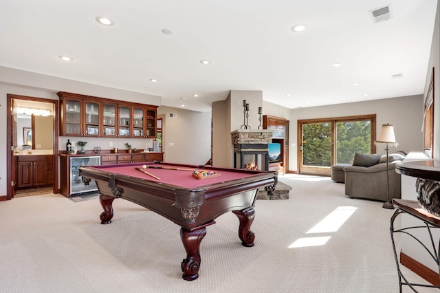 recreation room with beverage cooler, light colored carpet, indoor wet bar, recessed lighting, and a fireplace