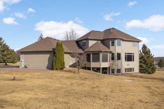 view of front facade with a shingled roof and a front lawn