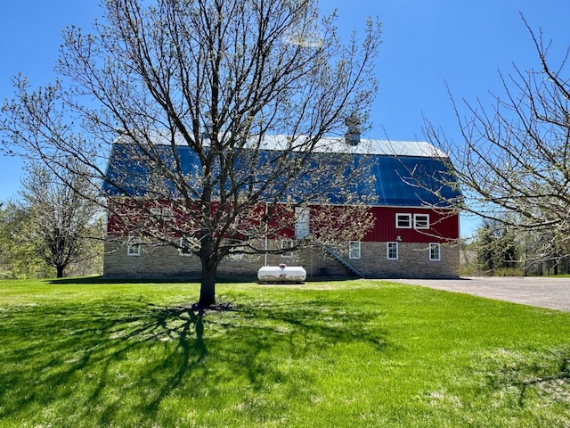 12326 Falk Trl, Northfield, MN 55057 - view of front facade with stone siding, a barn, a front lawn, and metal roof