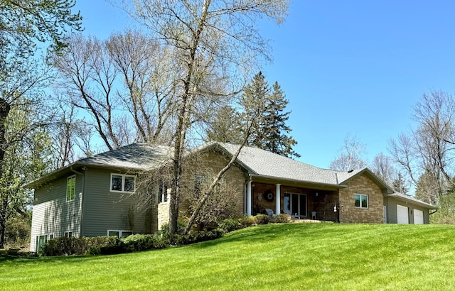 12326 Falk Trl, Northfield, MN 55057 - rear view of property featuring stone siding, a garage, and a yard