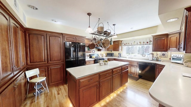 12326 Falk Trl, Northfield, MN 55057 - kitchen with black appliances, light wood-style floors, light countertops, a kitchen island, and decorative light fixtures