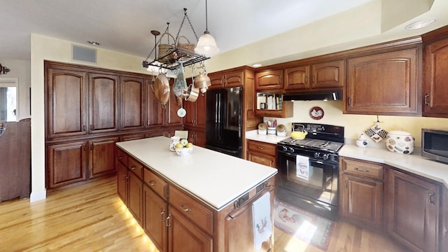 12326 Falk Trl, Northfield, MN 55057 - kitchen featuring black appliances, under cabinet range hood, a center island, and light countertops