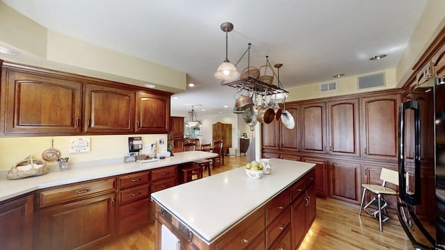 12326 Falk Trl, Northfield, MN 55057 - kitchen featuring freestanding refrigerator, light countertops, a center island, recessed lighting, and hanging light fixtures