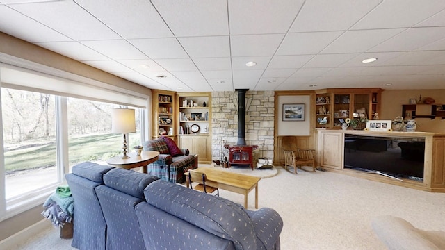 12326 Falk Trl, Northfield, MN 55057 - carpeted living room featuring a wood stove, built in features, and a drop ceiling