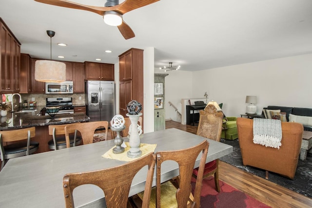 dining space with sink, ceiling fan, and dark hardwood / wood-style floors