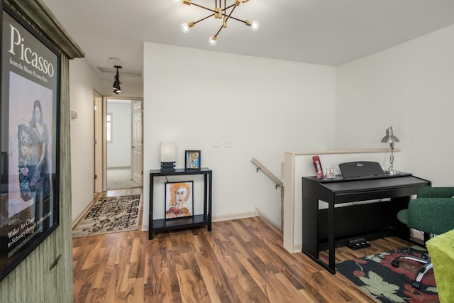 miscellaneous room featuring an inviting chandelier and dark hardwood / wood-style floors