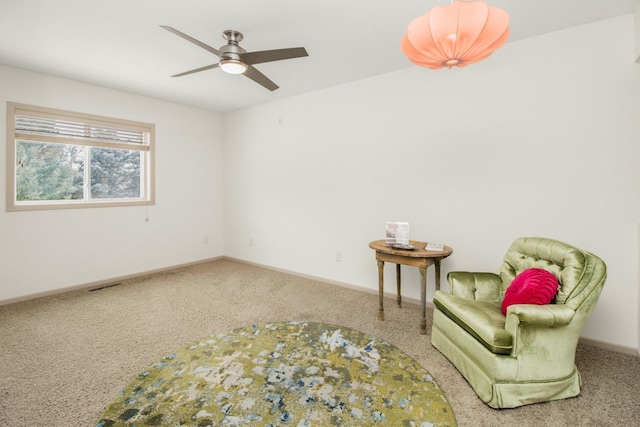 sitting room with ceiling fan and carpet