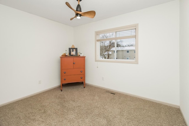 carpeted spare room with ceiling fan