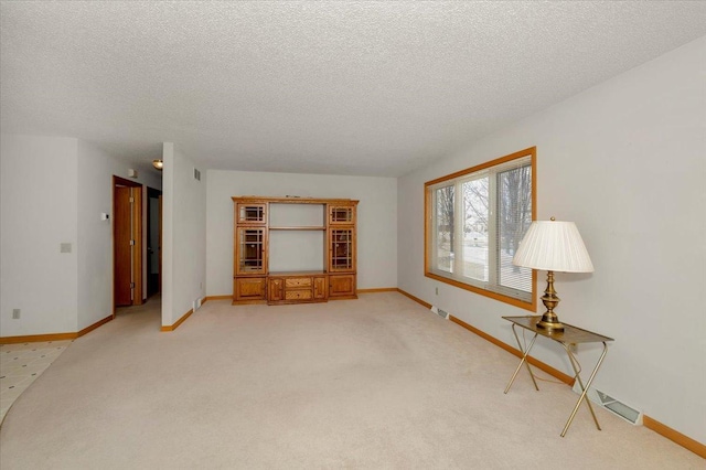 interior space featuring a textured ceiling and light carpet