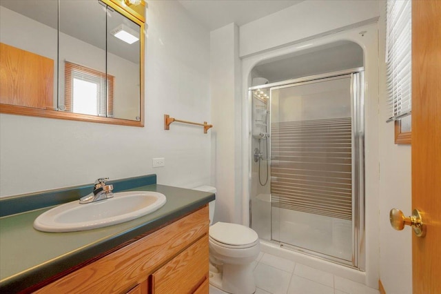 bathroom featuring walk in shower, vanity, tile patterned floors, and toilet