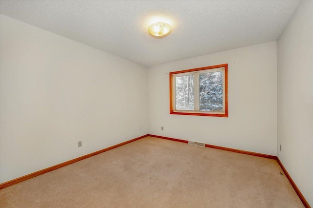 spare room with a textured ceiling and carpet