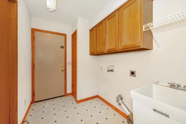 laundry area featuring a textured ceiling, sink, electric dryer hookup, cabinets, and washer hookup