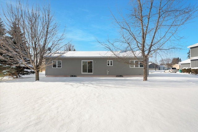 view of snow covered rear of property