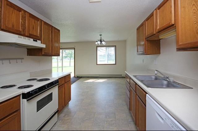 kitchen with white appliances, decorative light fixtures, a chandelier, and sink