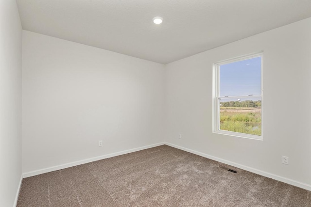 carpeted empty room featuring recessed lighting and baseboards