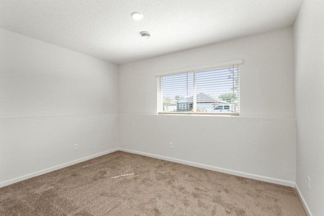 unfurnished room with baseboards, a textured ceiling, and carpet flooring