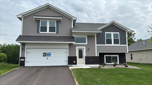 10108 Twin Lakes Pkwy NW, Elk River, MN 55330 - view of front facade featuring a garage, a shingled roof, asphalt driveway, a front yard, and board and batten siding