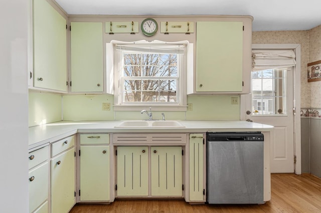 kitchen featuring a healthy amount of sunlight, dishwasher, sink, and light hardwood / wood-style floors