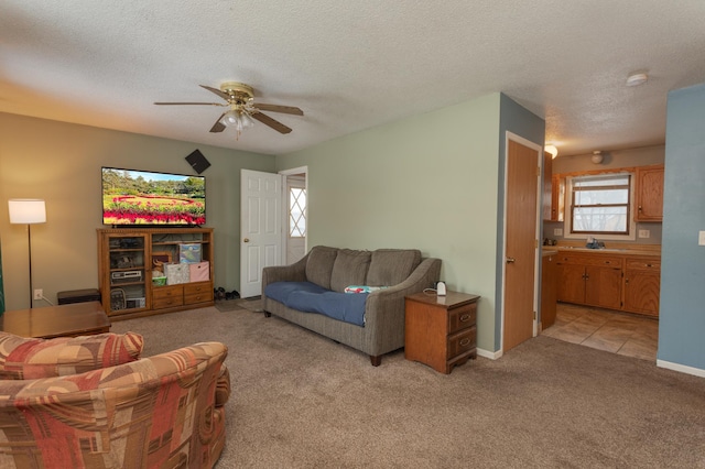 carpeted living room featuring a textured ceiling, ceiling fan, and sink