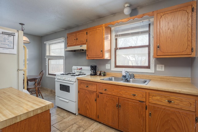 kitchen featuring sink, white appliances, and a textured ceiling