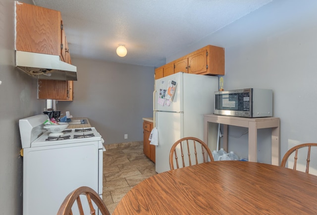 kitchen featuring white appliances and a textured ceiling