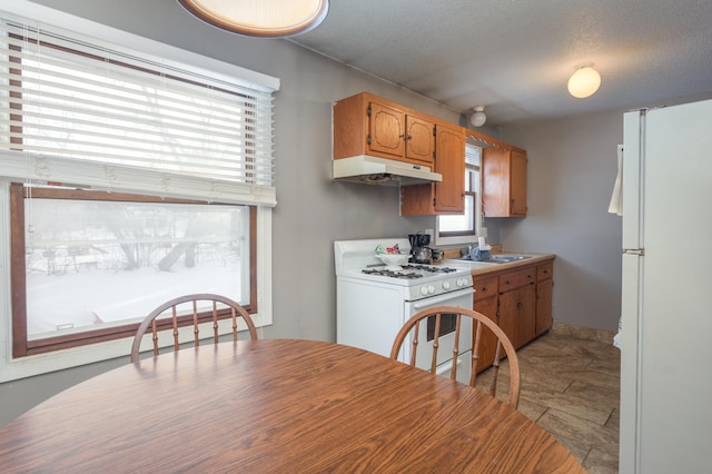 kitchen featuring a textured ceiling, sink, and white appliances