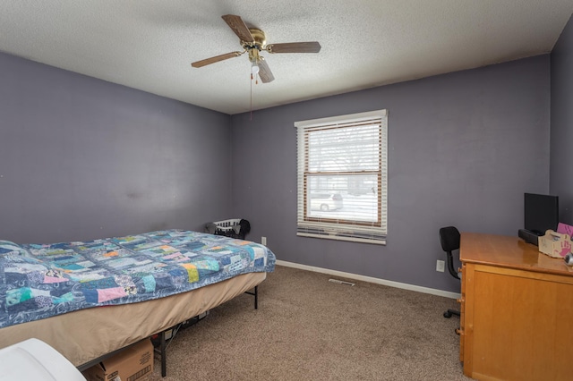 carpeted bedroom with ceiling fan and a textured ceiling