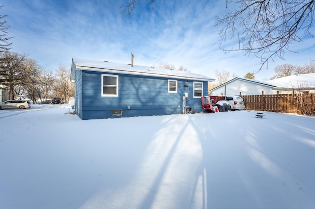 view of snow covered rear of property