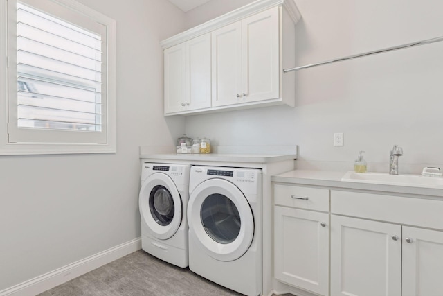 washroom featuring sink, washing machine and clothes dryer, and cabinets