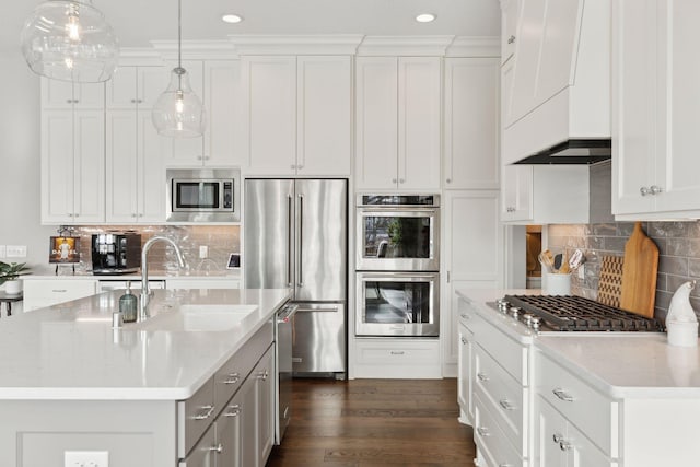 kitchen with stainless steel appliances, pendant lighting, white cabinets, and sink