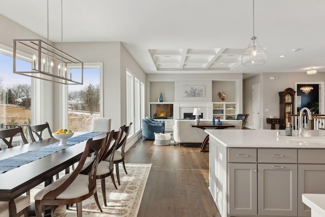 kitchen featuring dark hardwood / wood-style flooring, beamed ceiling, hanging light fixtures, gray cabinets, and coffered ceiling