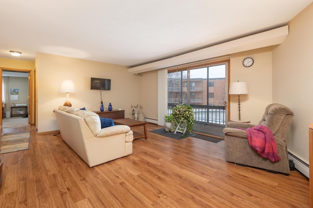 living room featuring light wood-type flooring and a baseboard heating unit