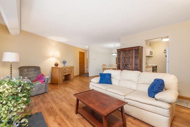 living room with light hardwood / wood-style floors and beam ceiling