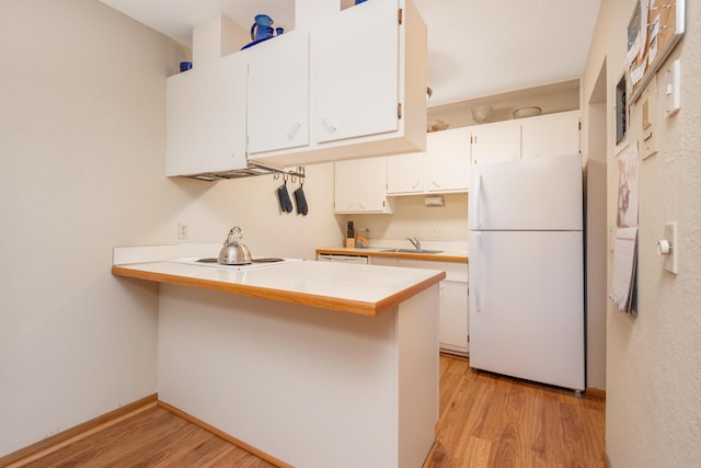 kitchen featuring white cabinets, kitchen peninsula, sink, and white appliances