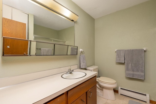 bathroom with toilet, vanity, baseboard heating, and tile patterned floors