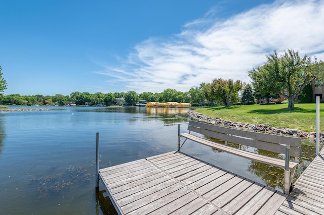 dock area with a water view and a lawn