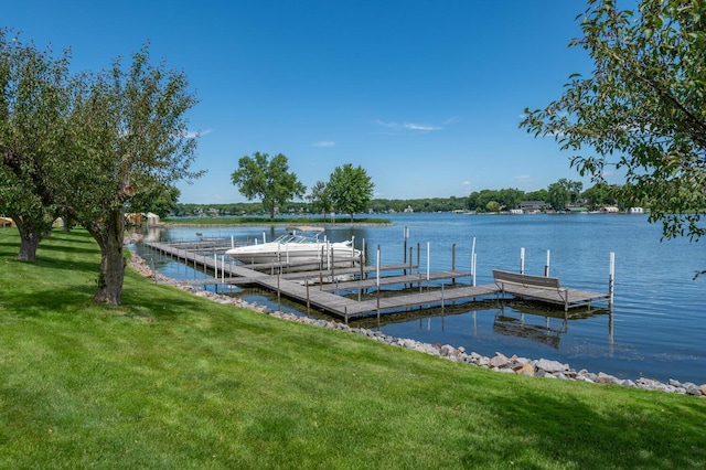 view of dock with a yard and a water view