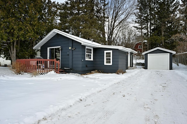 view of front of home with a garage, a deck, and an outdoor structure