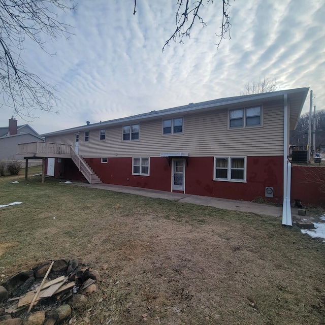 rear view of property with a yard, a patio, and a deck