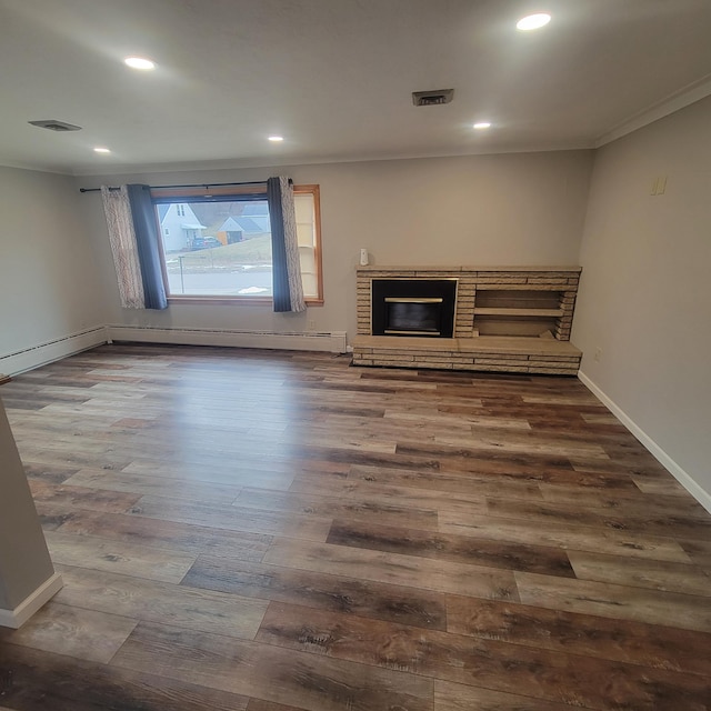 unfurnished living room featuring dark wood-type flooring, ornamental molding, and a brick fireplace