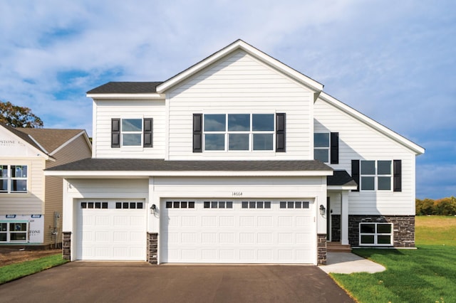 view of front of property featuring a front lawn and a garage