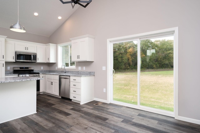 kitchen featuring stainless steel appliances, high vaulted ceiling, light stone countertops, and white cabinetry