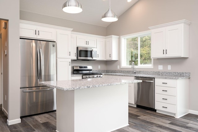 kitchen featuring stainless steel appliances, white cabinetry, a center island, and hanging light fixtures