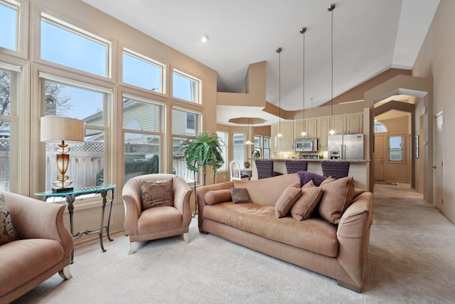 carpeted living room with high vaulted ceiling