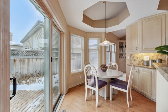 dining area featuring a tray ceiling and light hardwood / wood-style floors