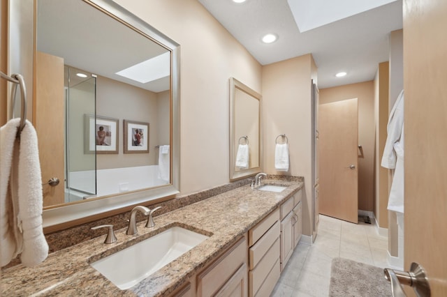 bathroom featuring tile patterned flooring, a skylight, and vanity