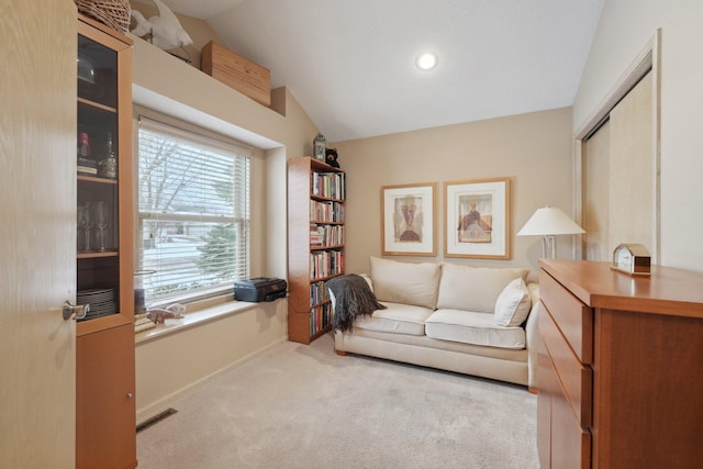 sitting room with lofted ceiling, a wealth of natural light, and light carpet