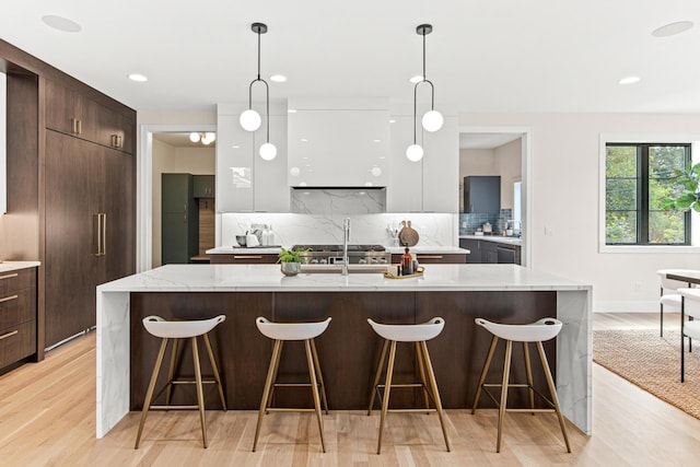 kitchen with a large island, a kitchen breakfast bar, and backsplash