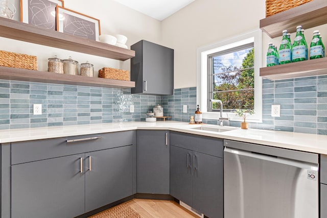 kitchen featuring sink, decorative backsplash, dishwasher, and gray cabinetry