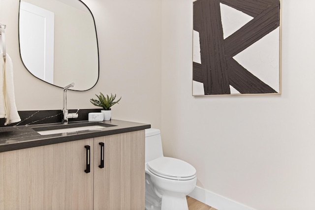 bathroom featuring wood-type flooring, vanity, and toilet